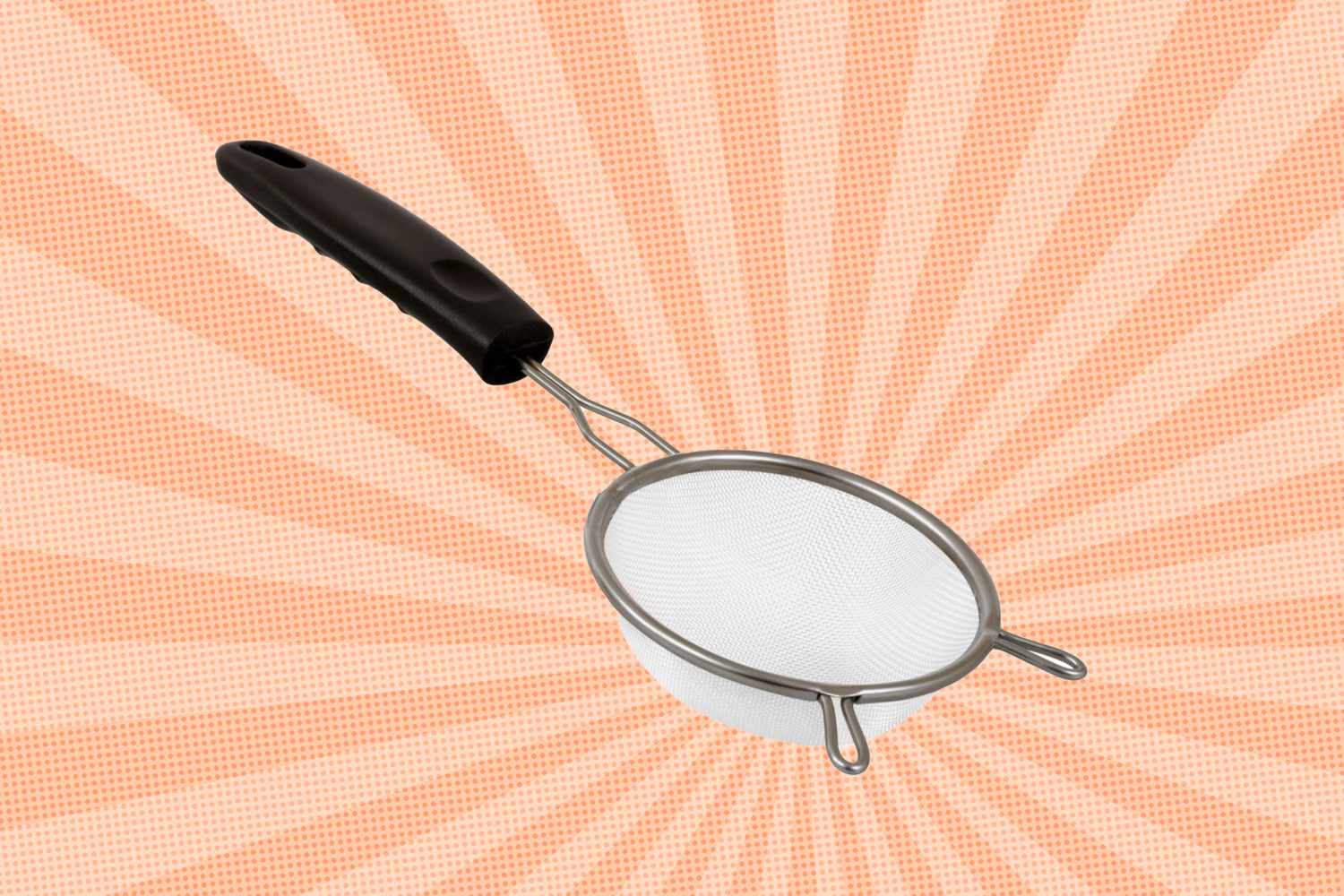 Mesh strainer with a black handle positioned against a patterned background