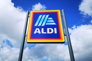 An Aldi logo on a sign in front of a sky with clouds