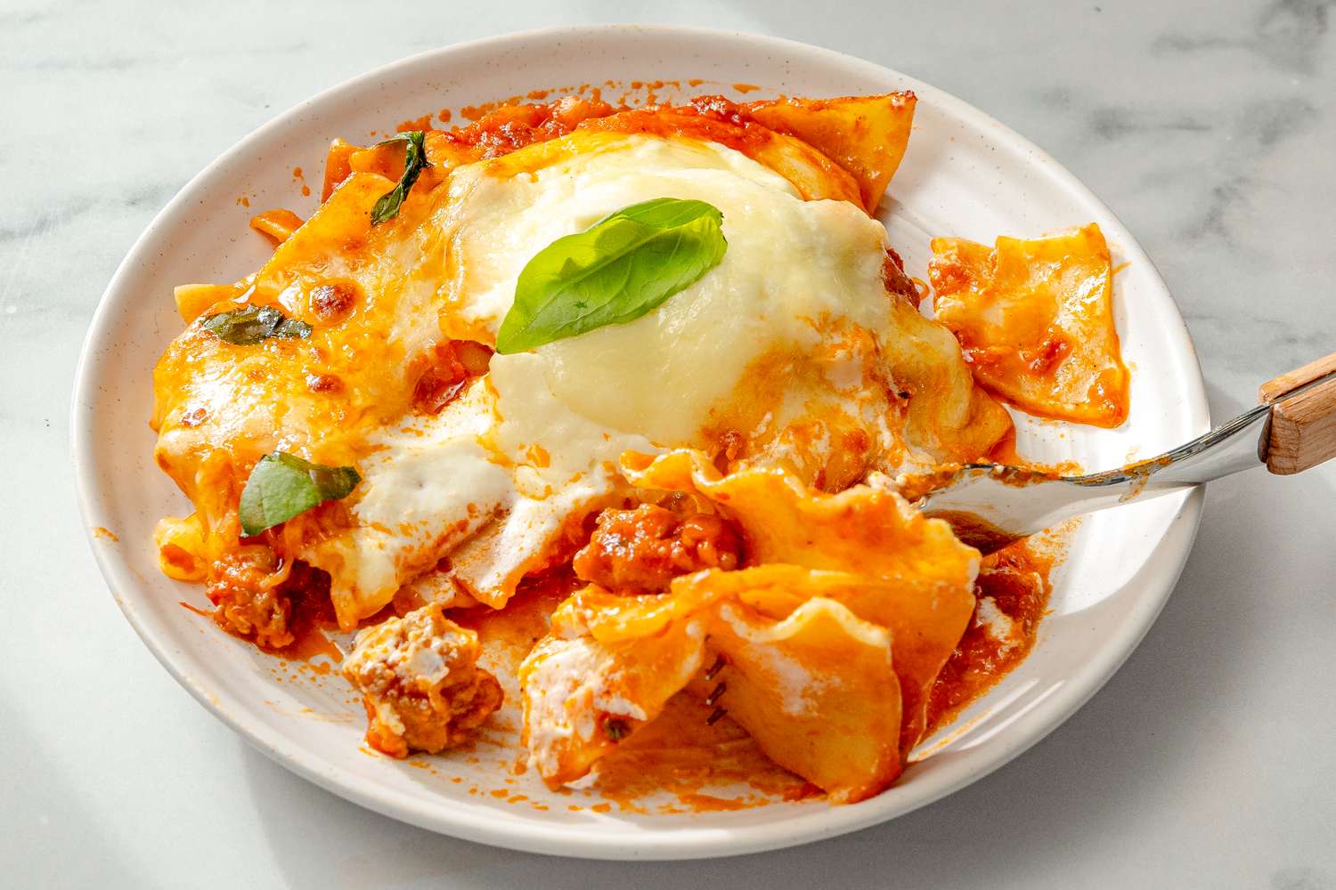 Skillet lasagna with a basil garnish served on a white plate