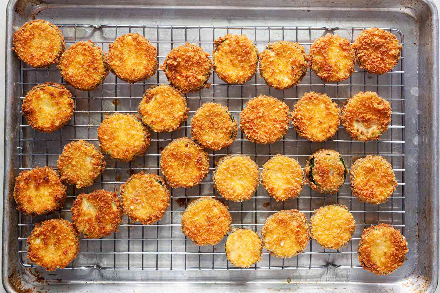 Fried Zucchini on a Cooling Rack with a Baking Sheet Underneath