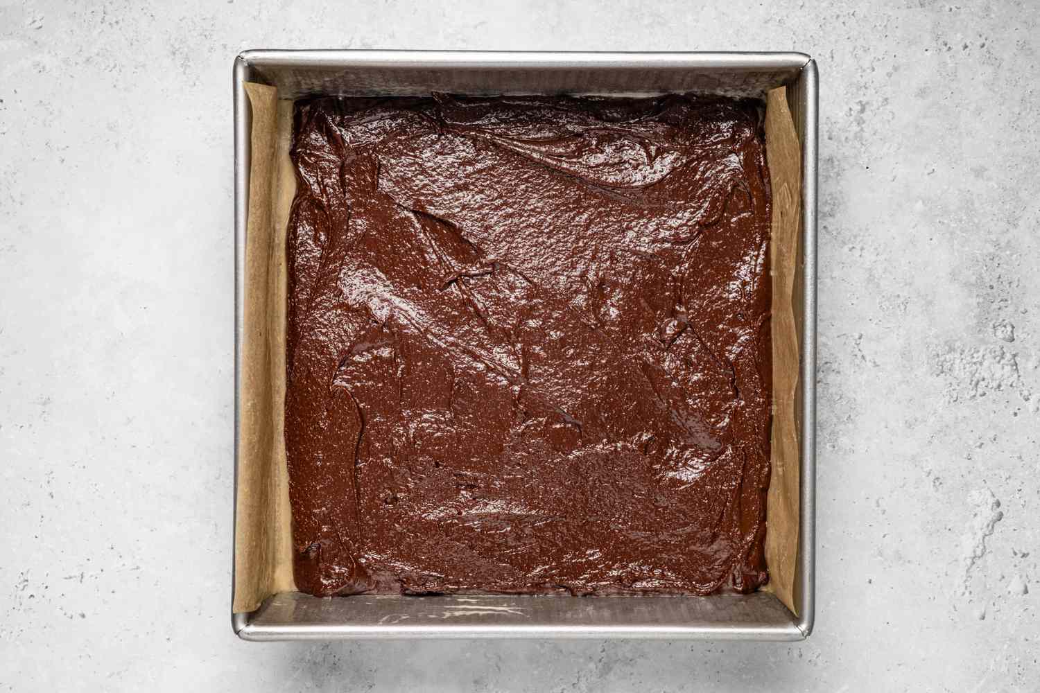 Brownie Batter Added to Lined Baking Pan for Banana Bread Recipe