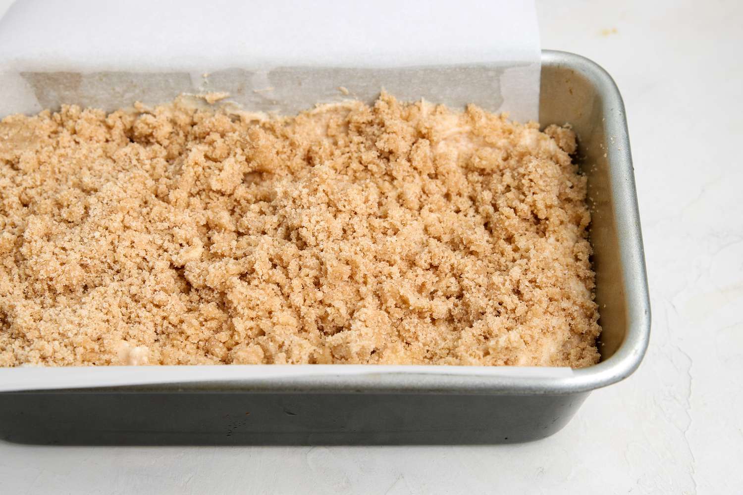 Loaf pan with cinnamon streusel apple bread ready to be baked.