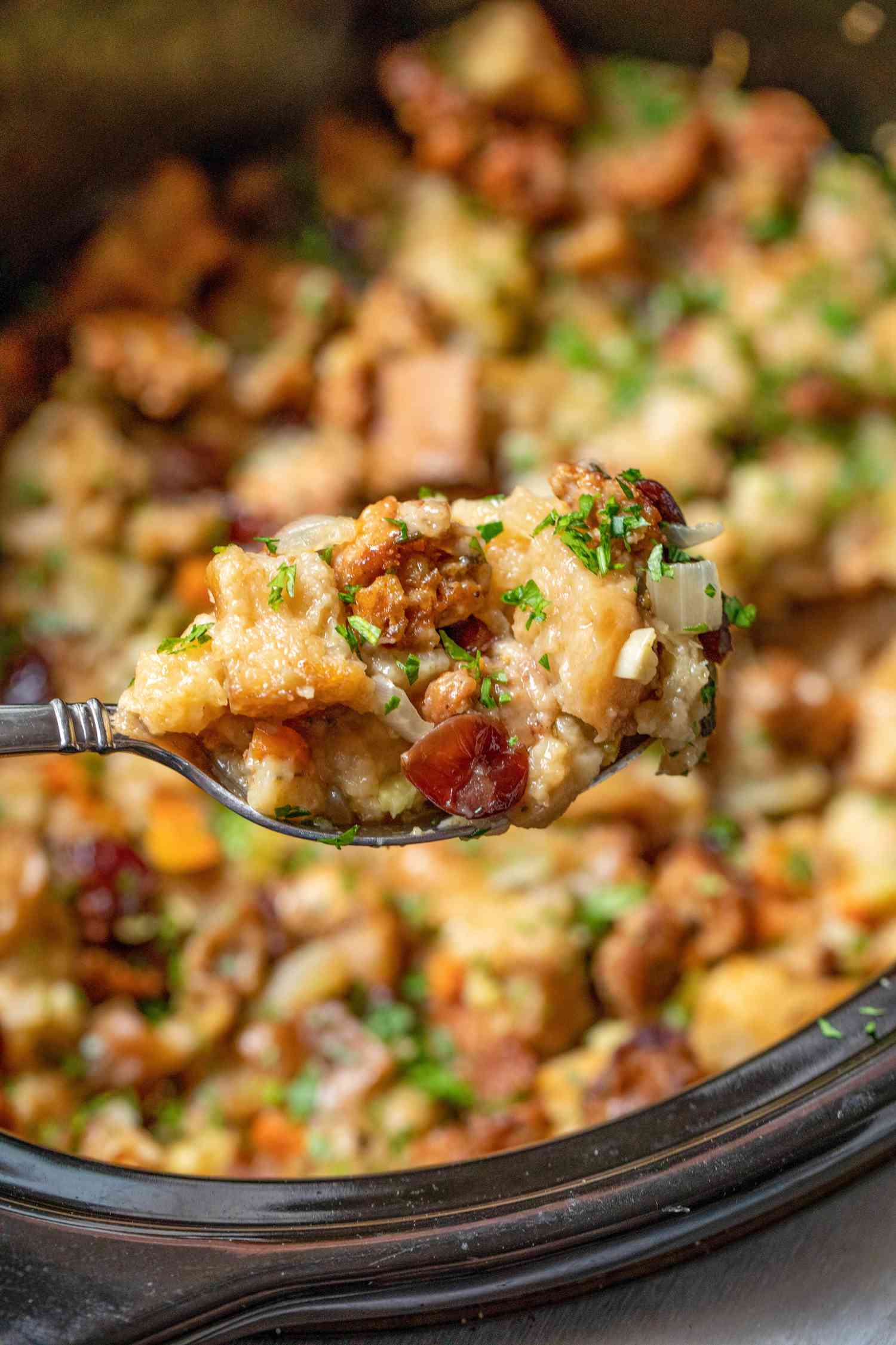 Slow Cooker Stuffing on a Spoon with More in the Background