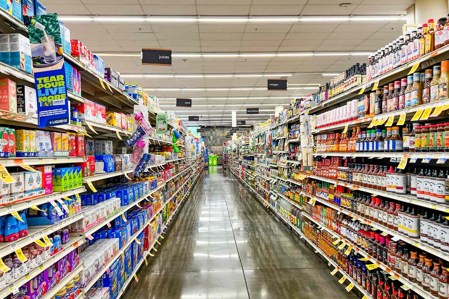 A grocery store aisle with shelves stocked on both sides