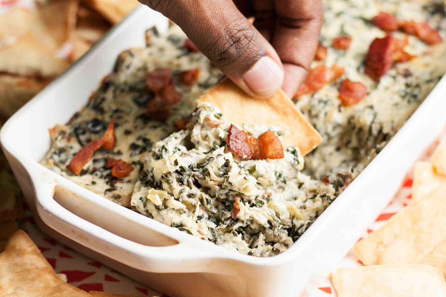 Easy Spinach Artichoke Dip with Bacon in a white casserole dish