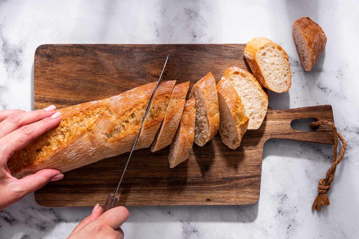Baguette cut into slices on a cutting board for bruschetta recipe