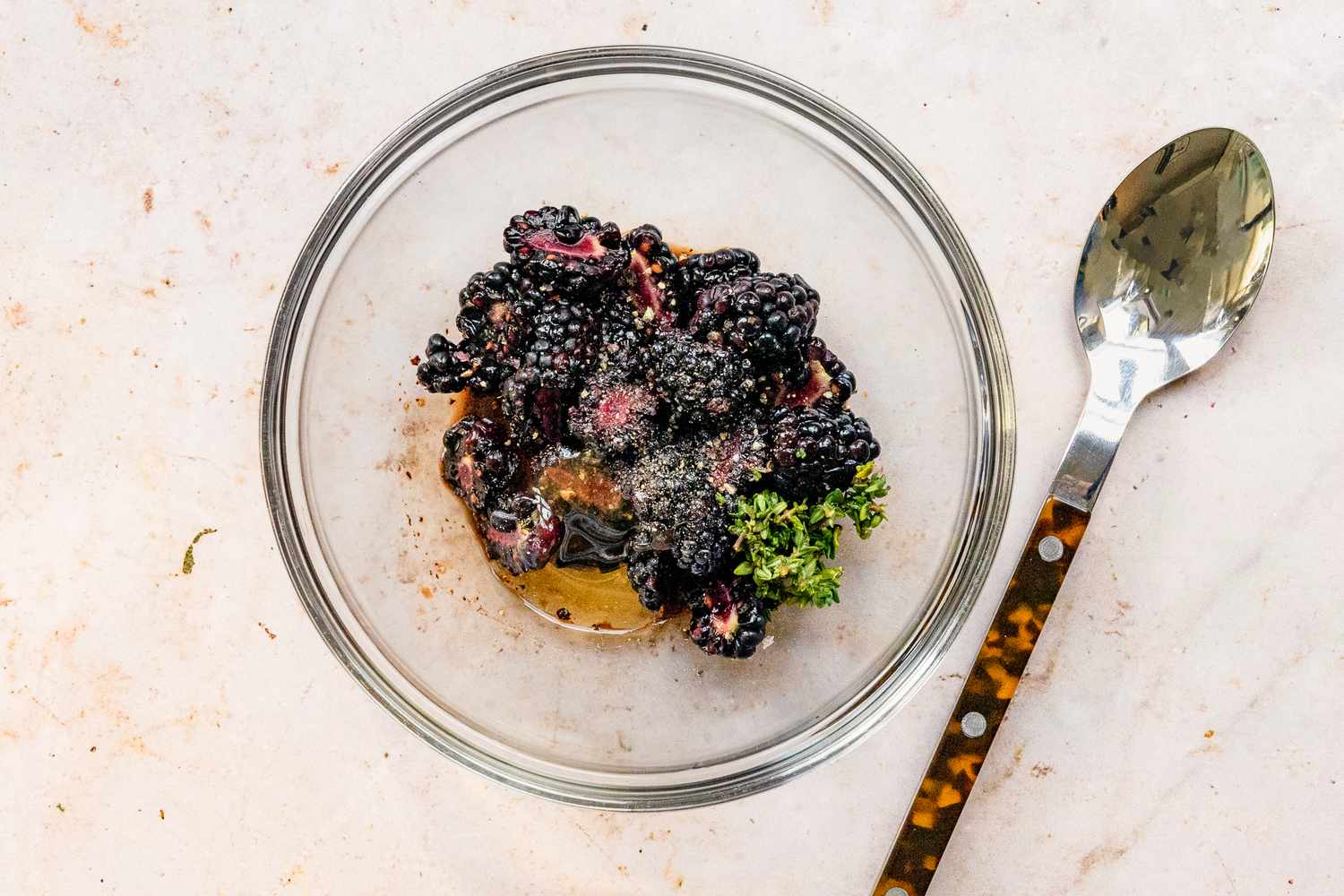 Bowl of Honey, Halved Blackberries, Fresh Thyme, and Seasoning for Cedar Plank Grilled Brie