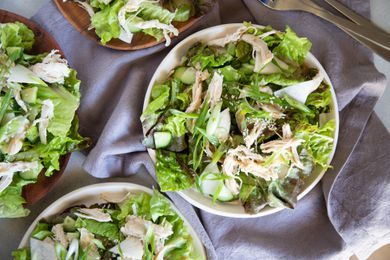 Overhead view of a table filled with bowls of quick chicken salad with tahini dressing