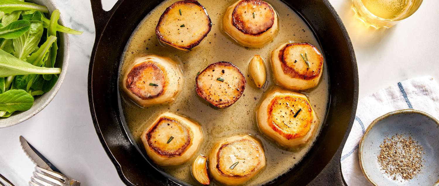 A skillet with cooked fondant potatoes on a table, ready to serve