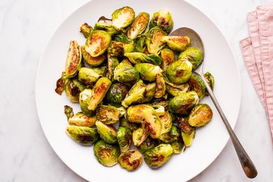 Roasted brussels sprout halves on a large white serving plate