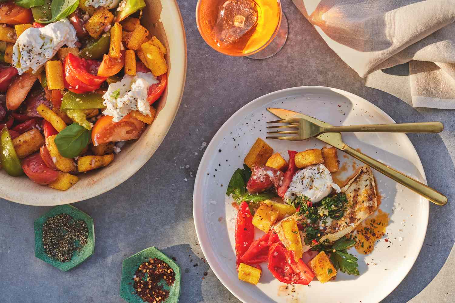 Gaby's Fried Polenta Panzanella plated with drinks in the sunlight