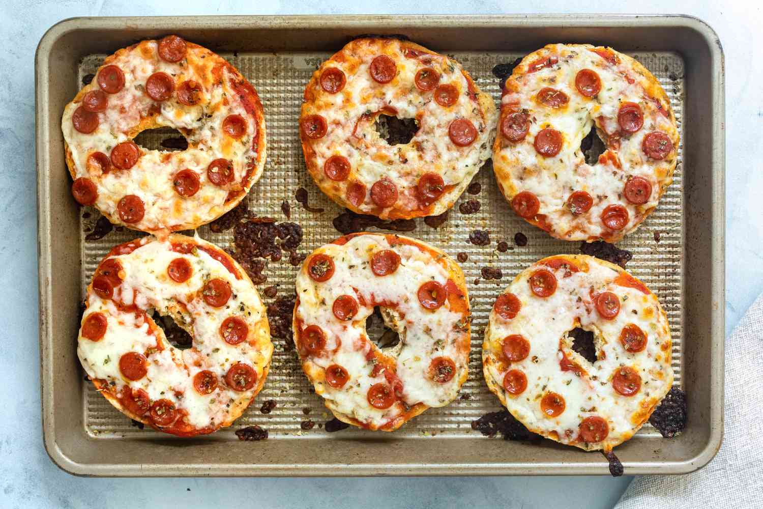 Baked pizza bagels on a sheet pan. 