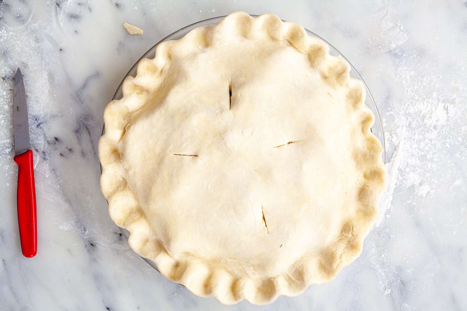 Cutting slits in a homemade pie crust.