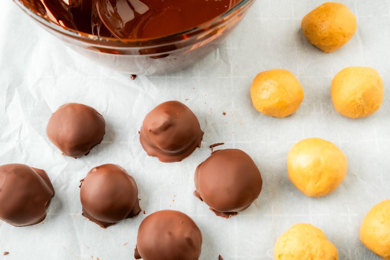 peanut butter balls, some dipped in chocolate and some not, bowl of chocolate for 4-Ingredient Peanut Butter Balls