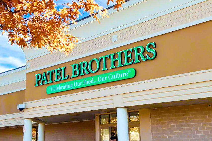 Exterior view of a Patel Brothers store front with their slogan prominently displayed