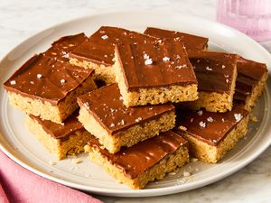 Angled view of sliced squares of Scotcheroos stacked on a plate