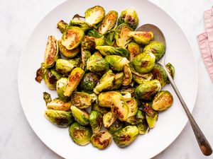 Roasted brussels sprout halves on a large white serving plate
