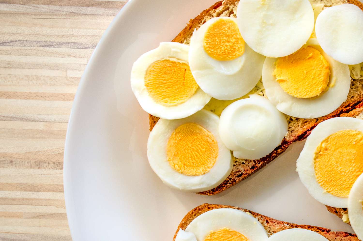 slices of toast topped with sliced hardboiled eggs, all on a plate
