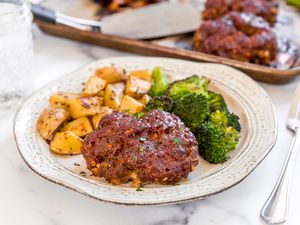 Sheet pan meatloaf dinner on a plate with broccoli and potatoes.