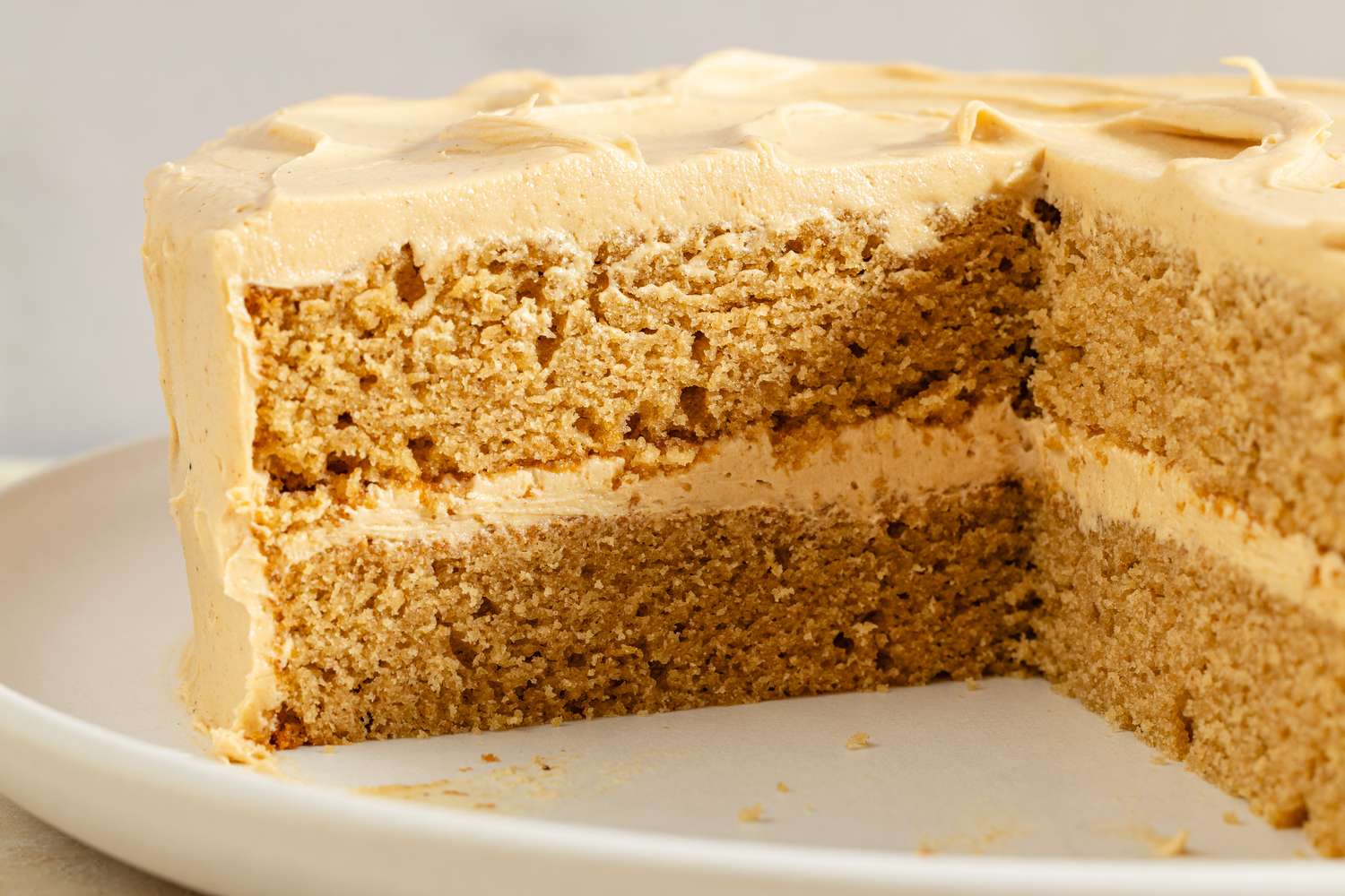 A sliced peanut butter cake with frosting on a plate