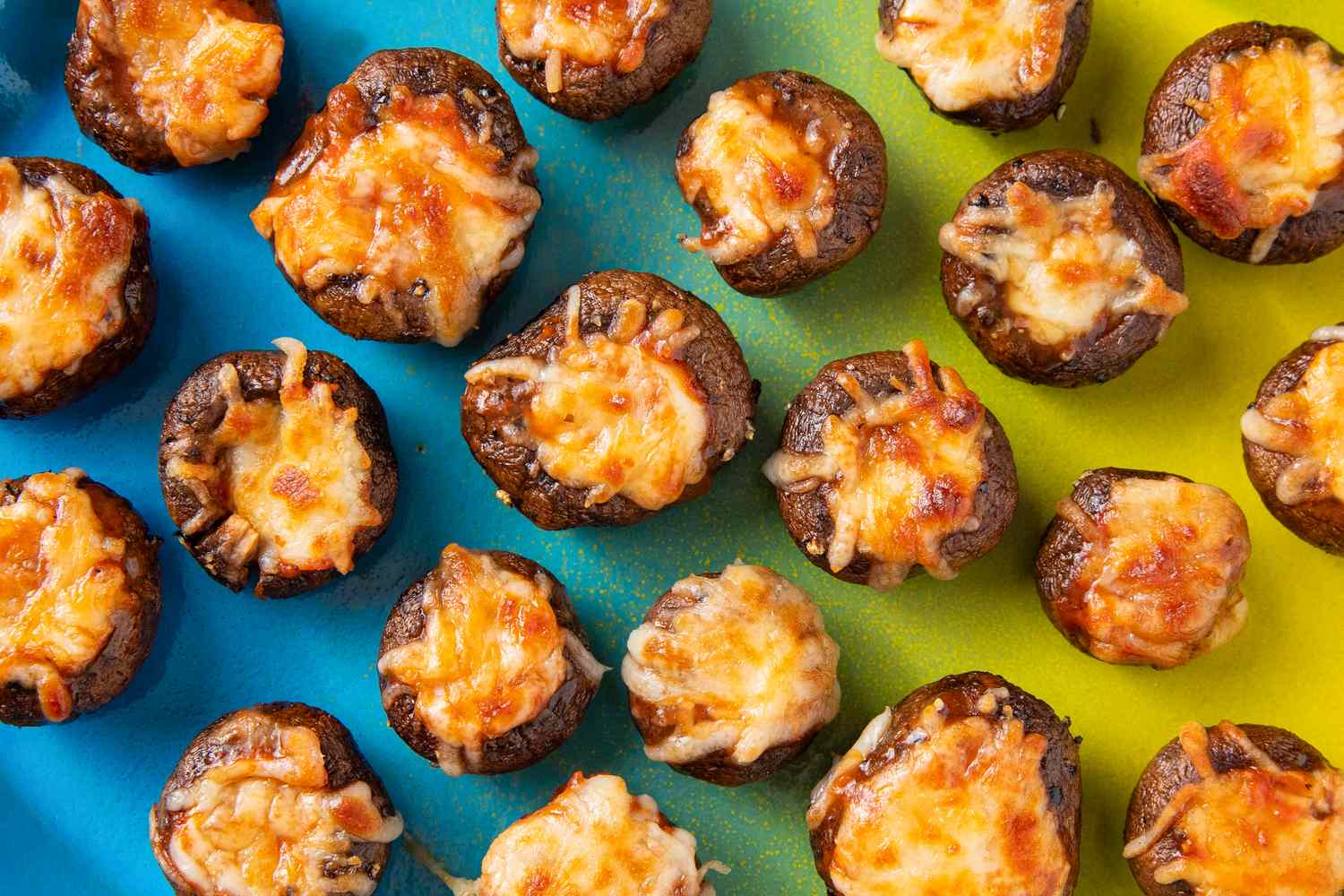 Baked stuffed mushrooms topped with melted cheese displayed on a colorful background