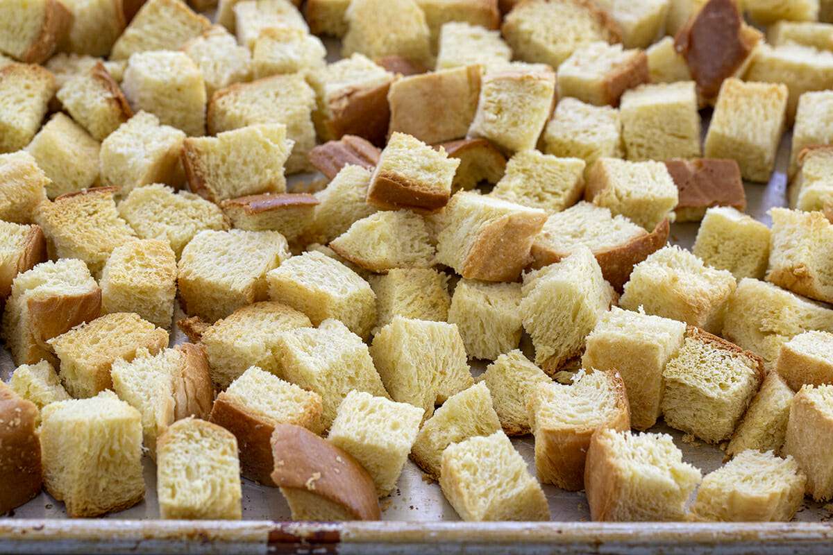 Bread slices cut into cubes on a baking sheet.