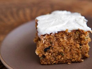 A plated square slice of zucchini cake with cream cheese frosting