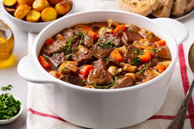 Beef stew in a white Dutch oven