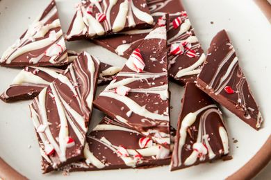 Pieces of chocolate peppermint bark on a plate featuring a mix of dark and white chocolate with candy cane bits