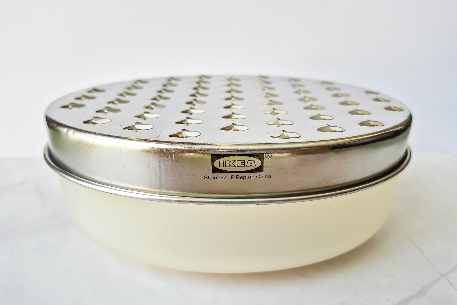 A stainless steel Ikea cheese grater with a detachable bowl