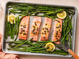 sheet pan salmon topped with lemon and capers next to asparagus