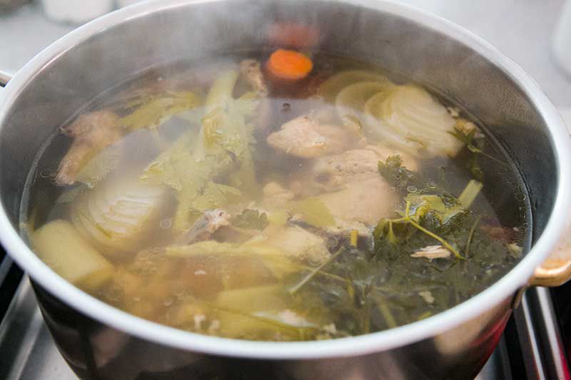 Chicken stock ingredients simmering in a stock pot