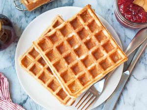 Easy waffle recipe served on a round plate with maple syrup