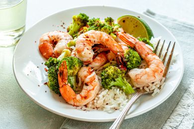 Spicy Honey Roasted Shrimp and Broccoli on a white plate with a fork.