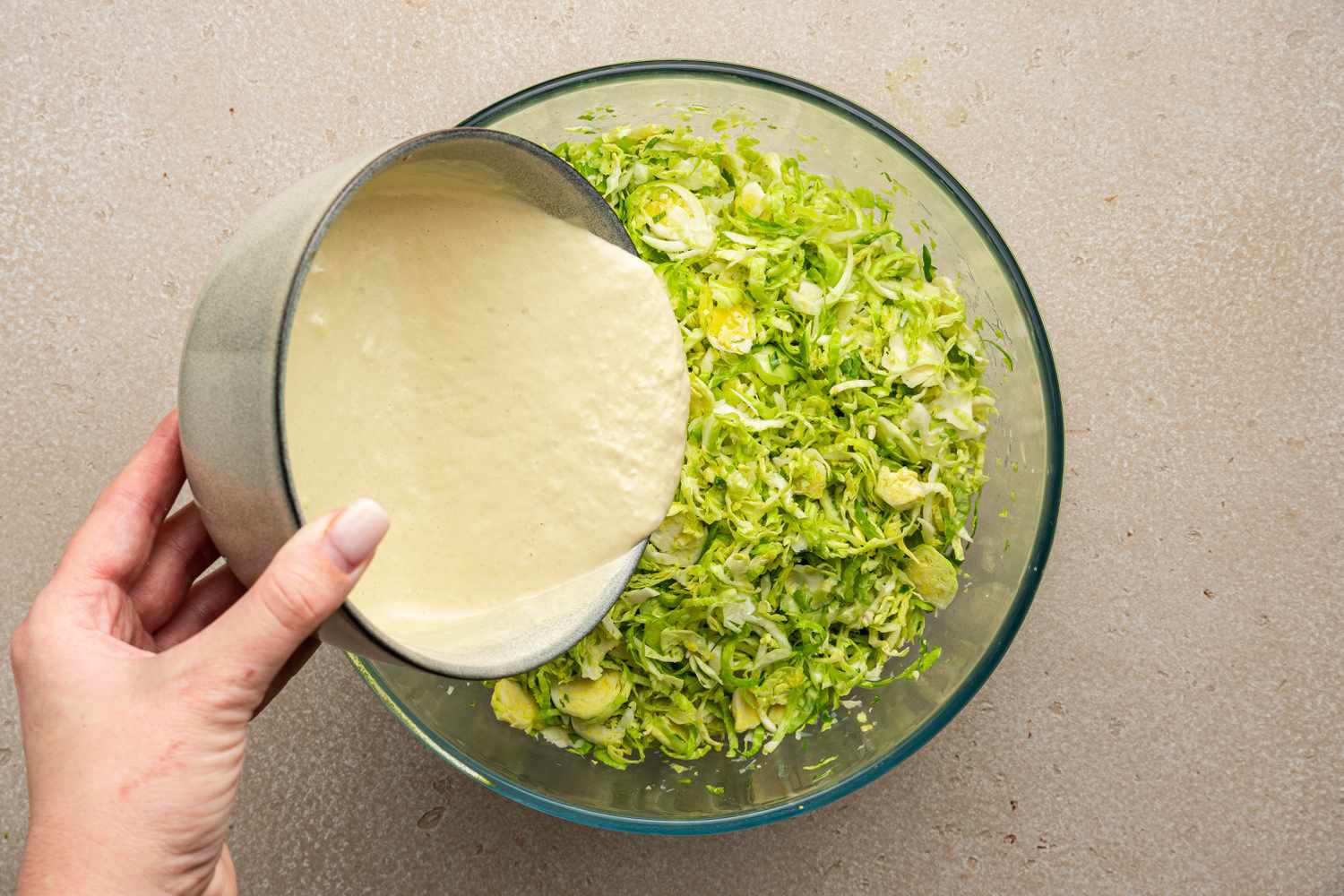 Caesar Dressing Poured into the Bowl of Shredded Brussels Sprouts