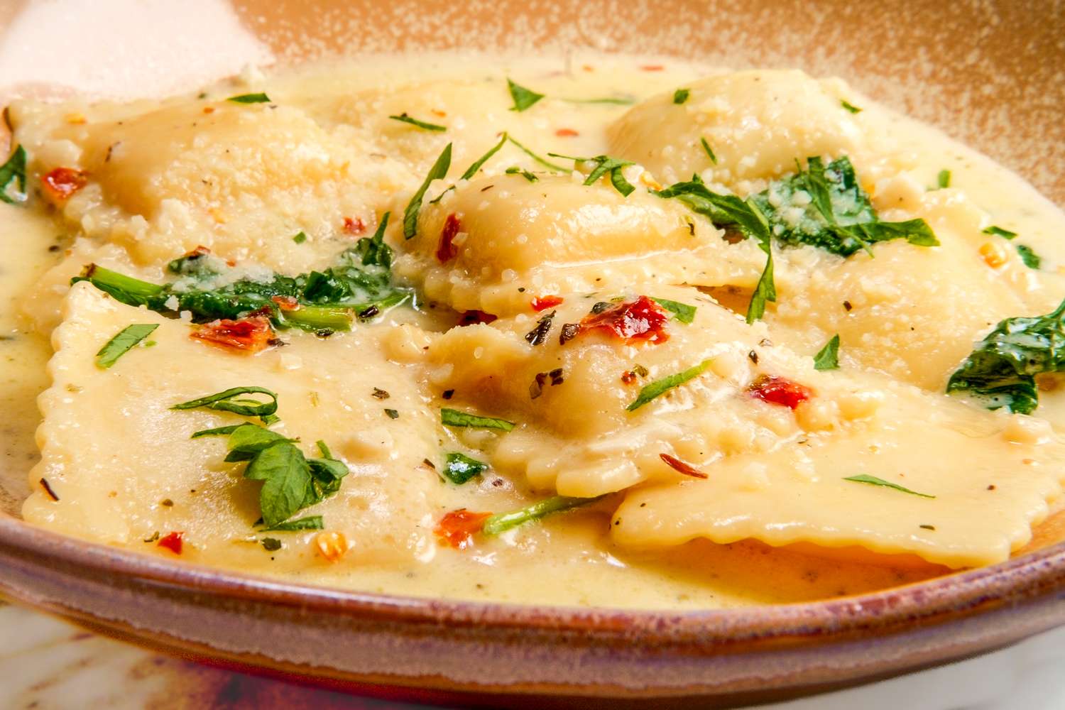 Ravioli on a plate with garnish and sauce