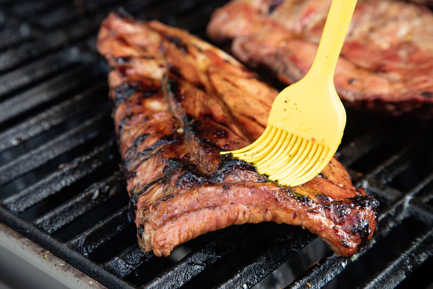 Basting grilled bbq ribs.