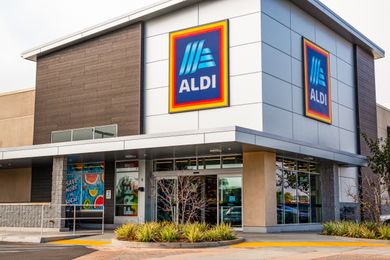 The entrance of an Aldi grocery store with large logo signage on the building
