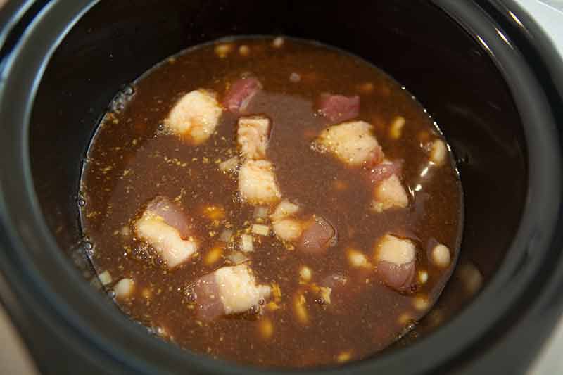 Baked beans beginning to cook in slow cooker