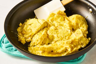 Scrambled eggs cooking in a skillet with a spatula