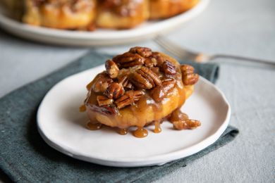 Cinnamon buns with pecans on a plate.