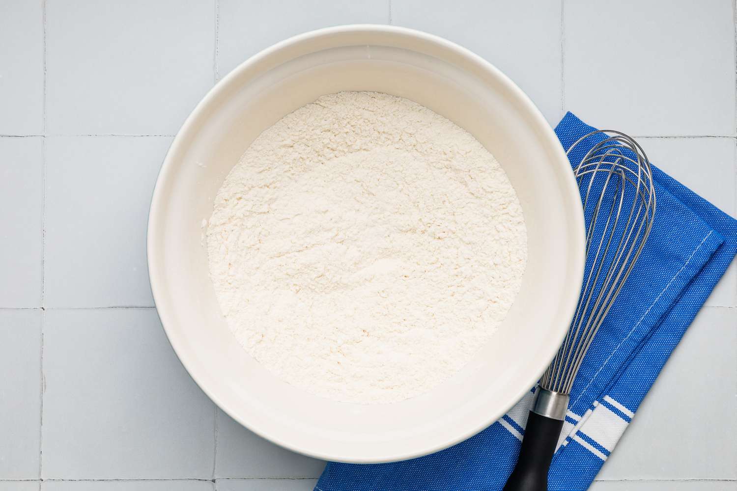 Drop biscuit dry ingredients in a bowl with a whisk next to it on the counter