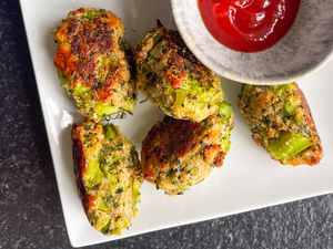 broccoli tots on a plate next to a bowl of ketchup
