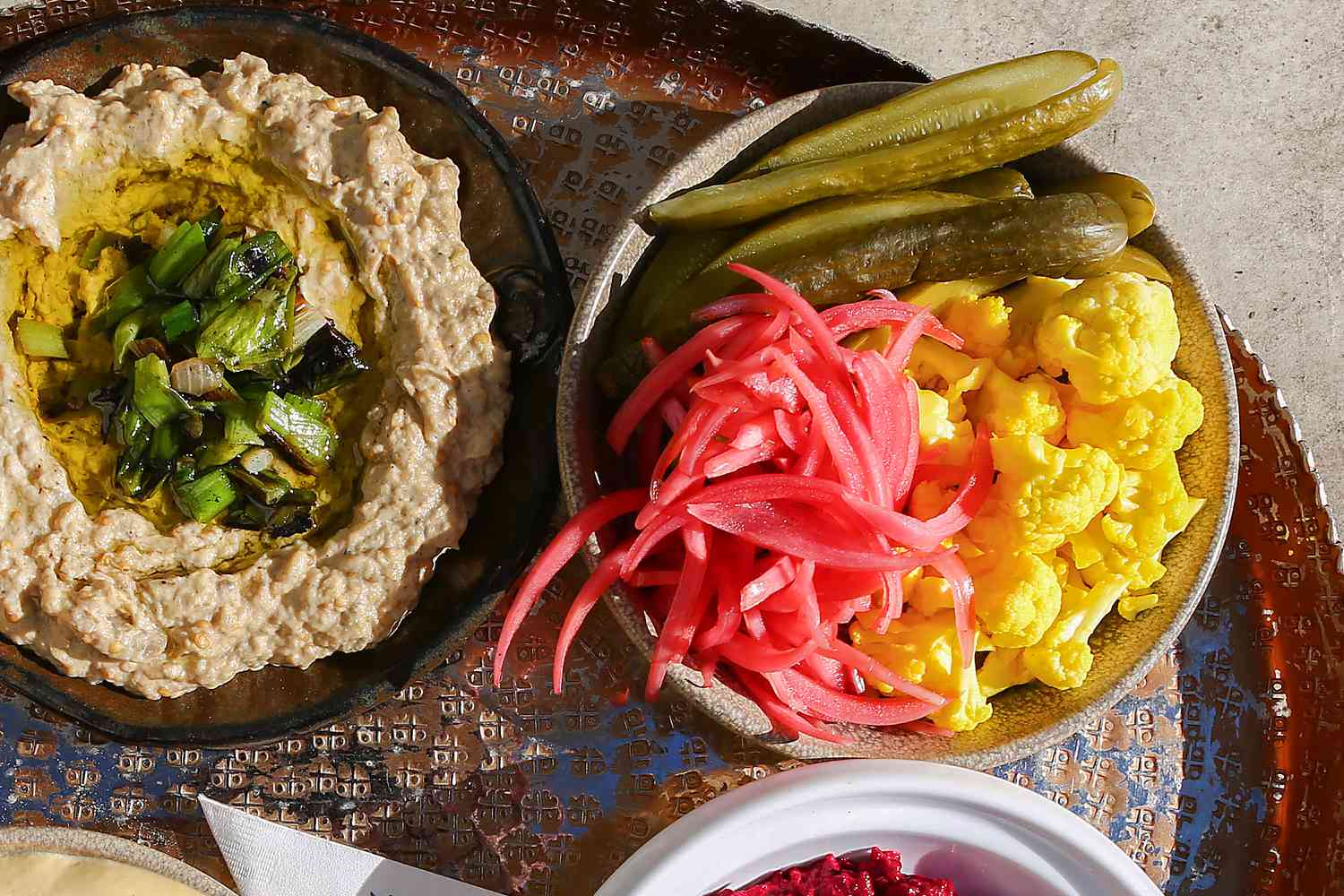 overhead view of plates of appetizers and pickled veggies