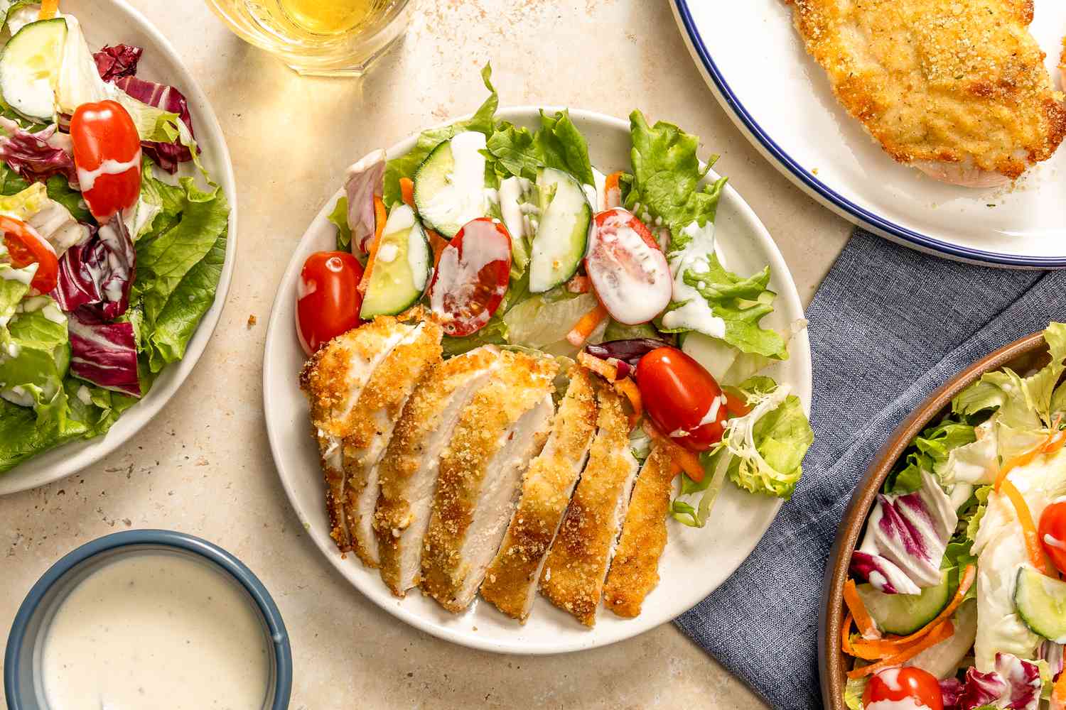 Overhead view of a plate with a sliced ranch baked chicken breast and salad