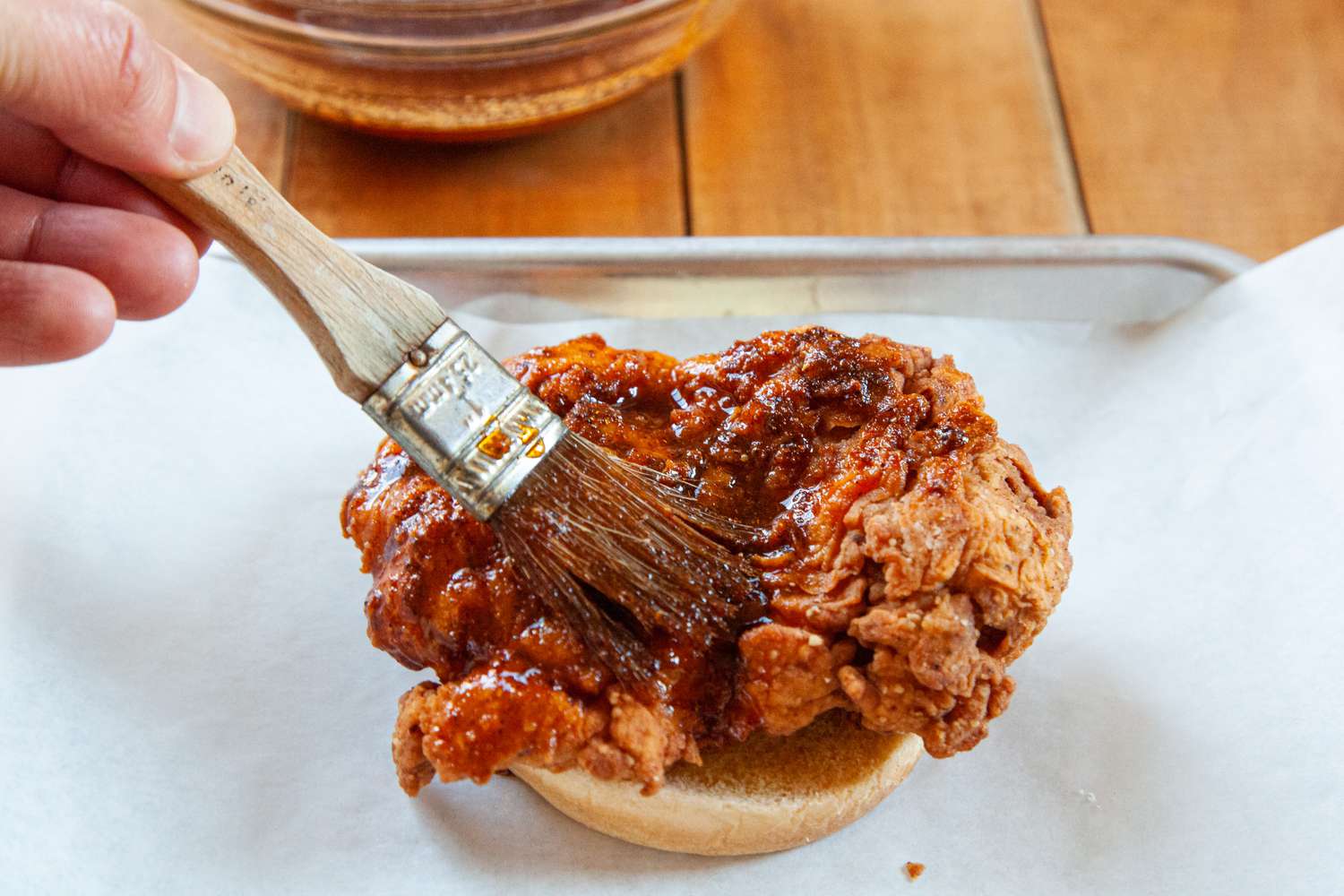 Adding spicy sauce to Nashville-style hot chicken.