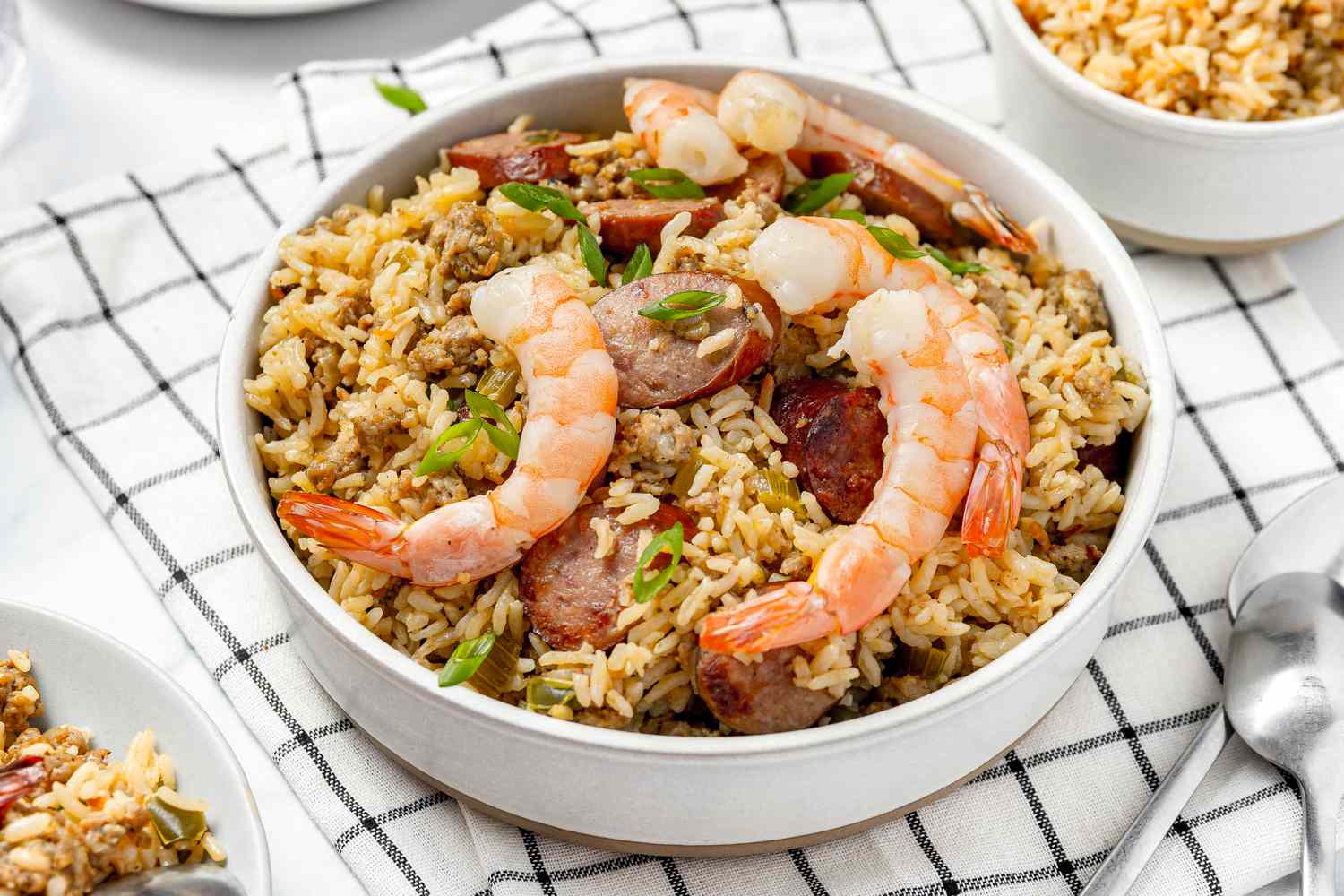 Bowl of Dirty Rice With Shrimp Next to Two Bowls of Rice