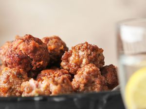 Plate with tasty sausage cheese balls on table
