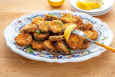 Fried Zucchini on a Platter with a Lemon Wedge and Fork