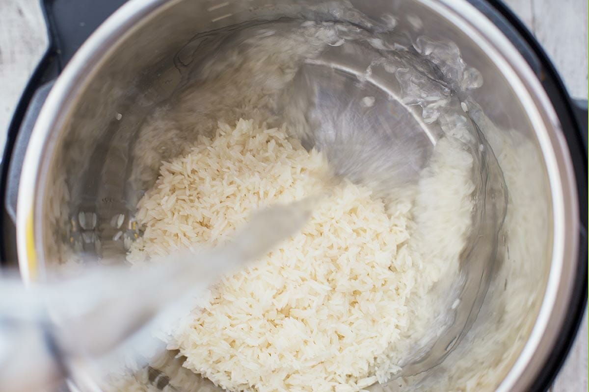 Water being added to the raw white rice in an instant pot 